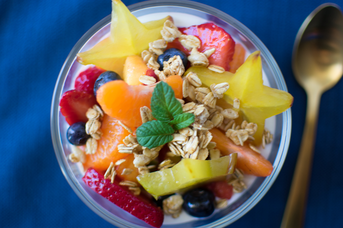Overhead closeup picture of Meal Prep Fruit Salad in a bowl with yogurt and granola