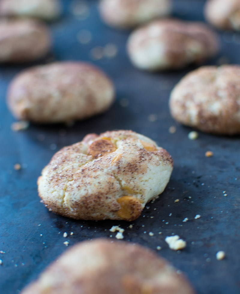 Close up of one cookie on a dark baking sheet