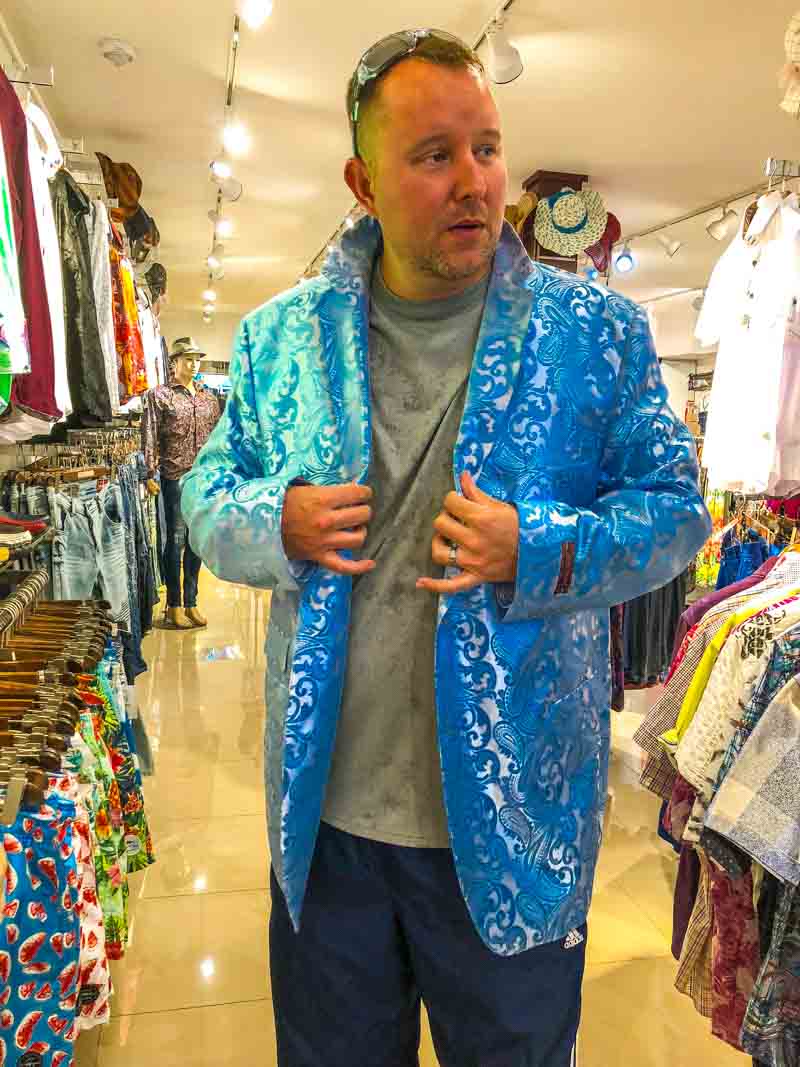 The husband trying on a shiny blue jacket