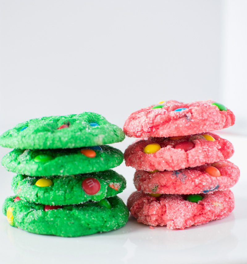 4 green and 4 red M&M Crinkle Christmas Cookies stacked on plate