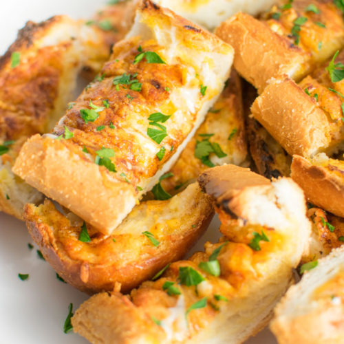 Close up of slices of Cheesy Ranch Garlic Bread on a plate