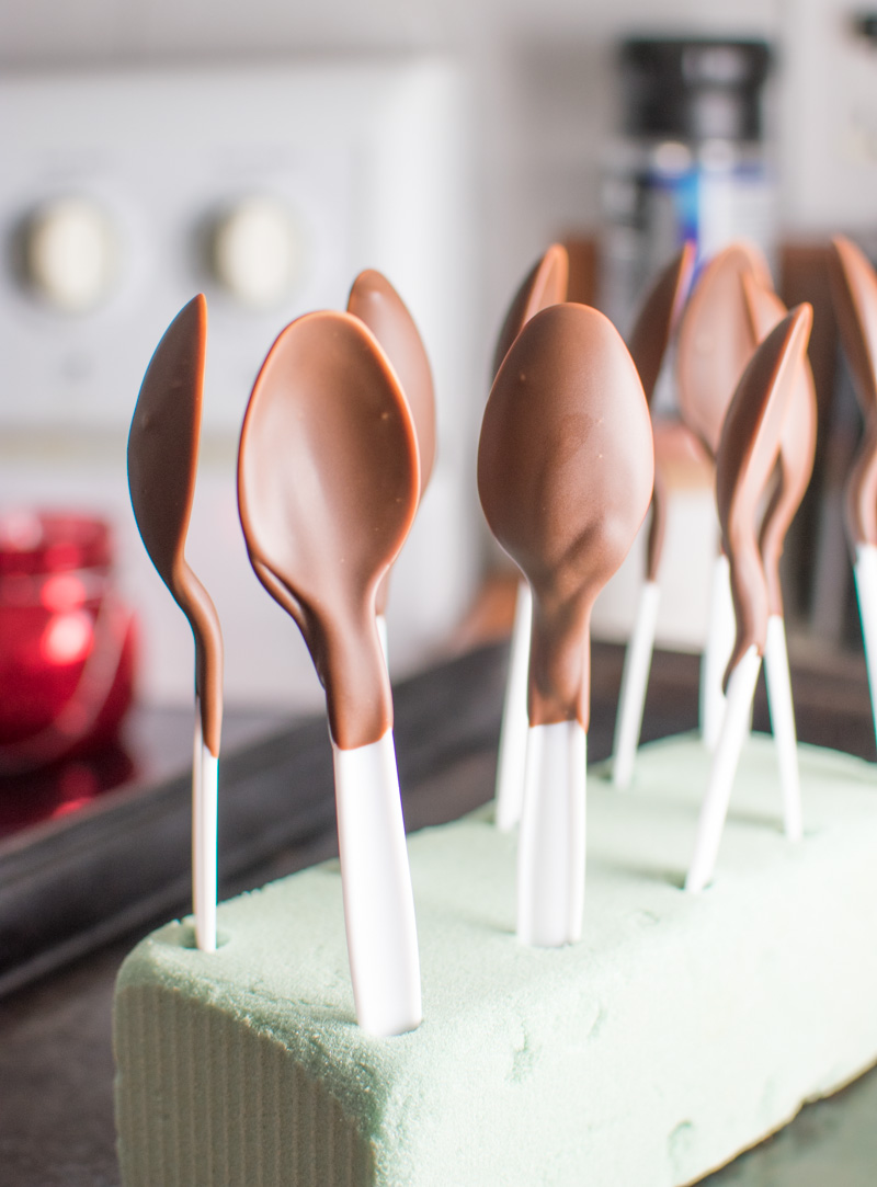 Spoons coated with first layer of chocolate