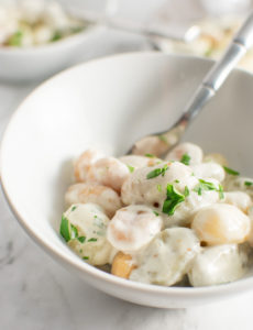 Close up of Gnocchi with Gorgonzola cream sauce in a bowl with a fork