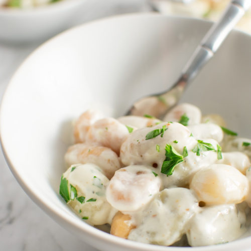 Close up of Gnocchi with Gorgonzola cream sauce in a bowl with a fork