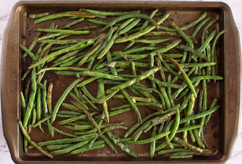 Overhead view of crispy browned beans on a baking sheet