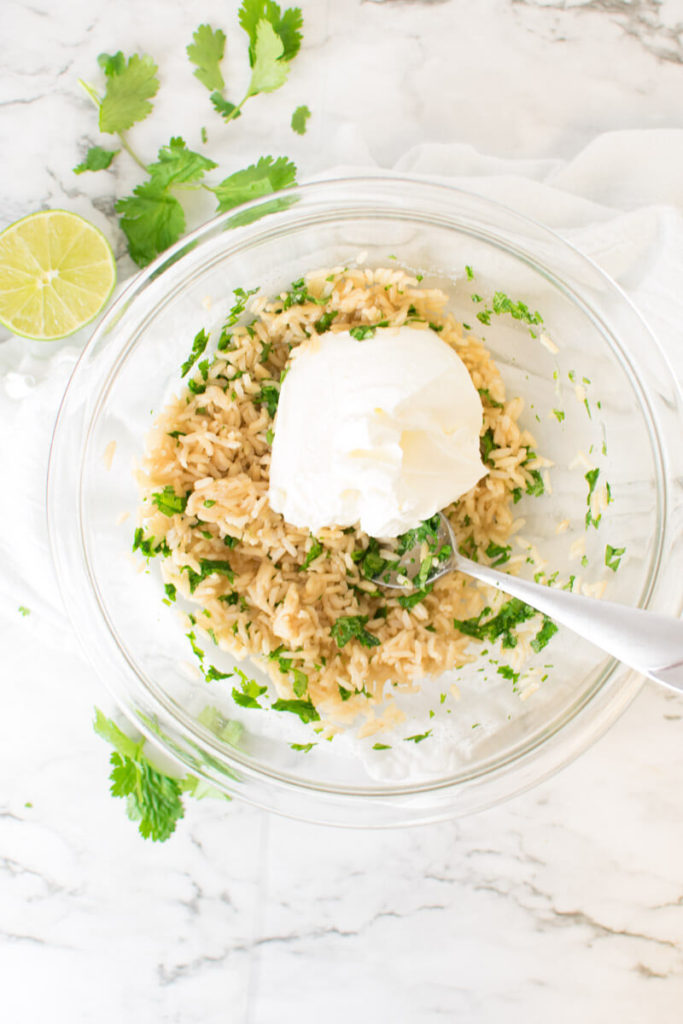 cilantro lime rice and sour cream in a mixing bowl