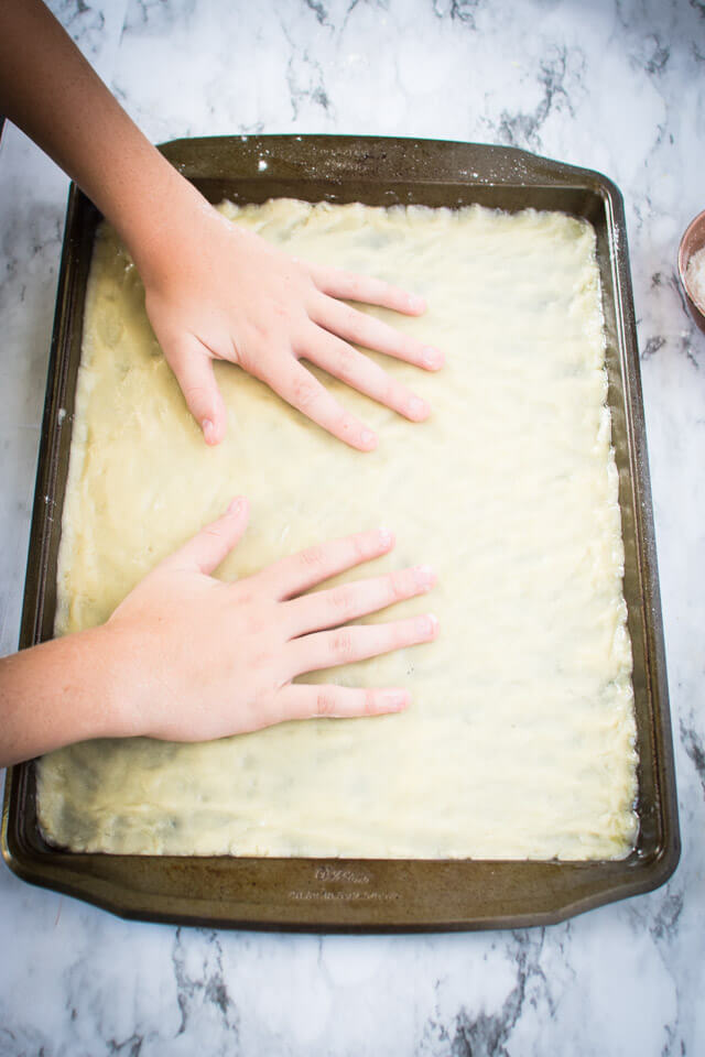 Spreading cookie dough in baking sheet pan