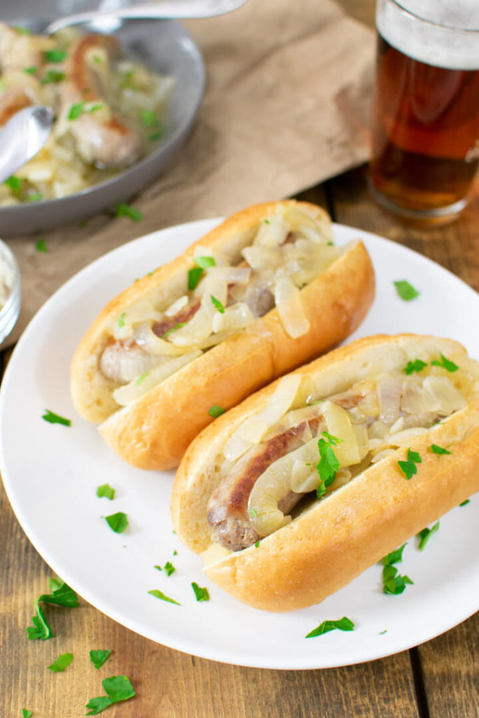 Two butter beer brats in buns on a plate