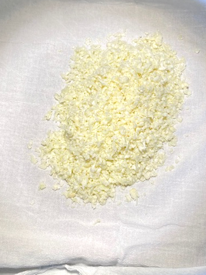 Cooked cauliflower rice on a flour sack towel
