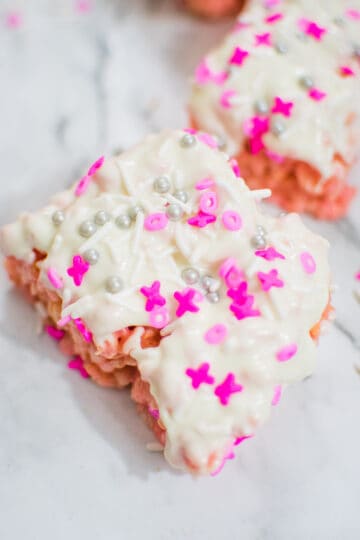 close up of pink and white Krispie treat with sprinkles on top