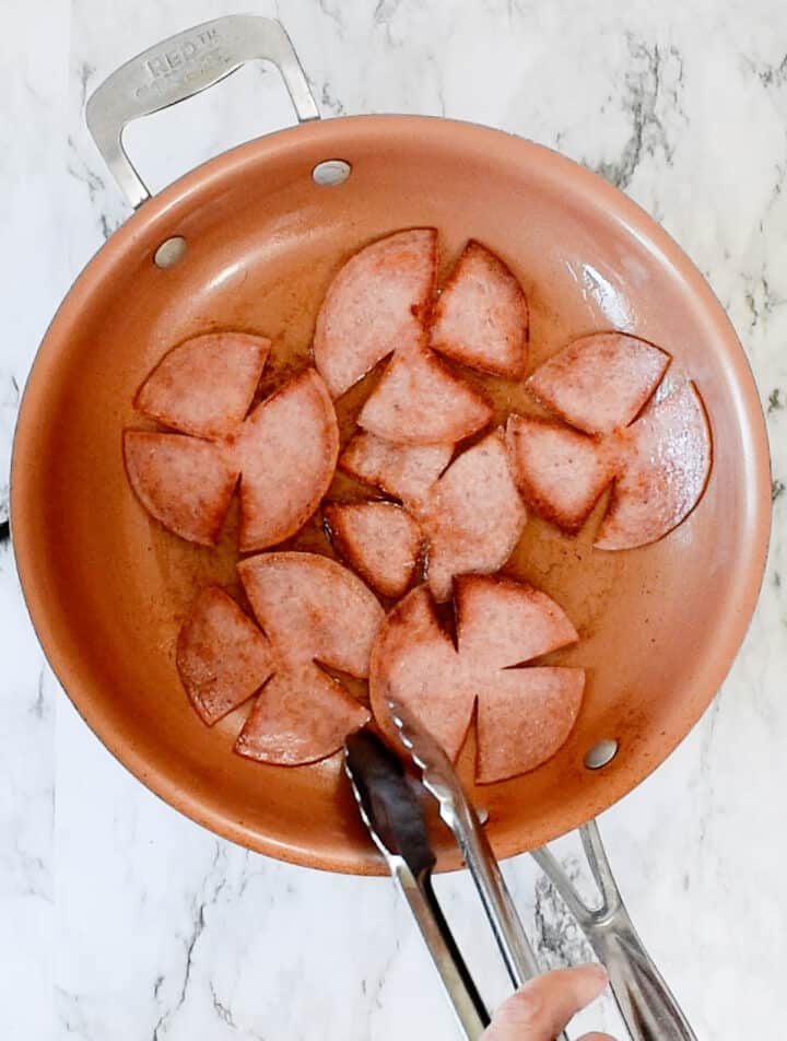 pork roll cooking in a skillet
