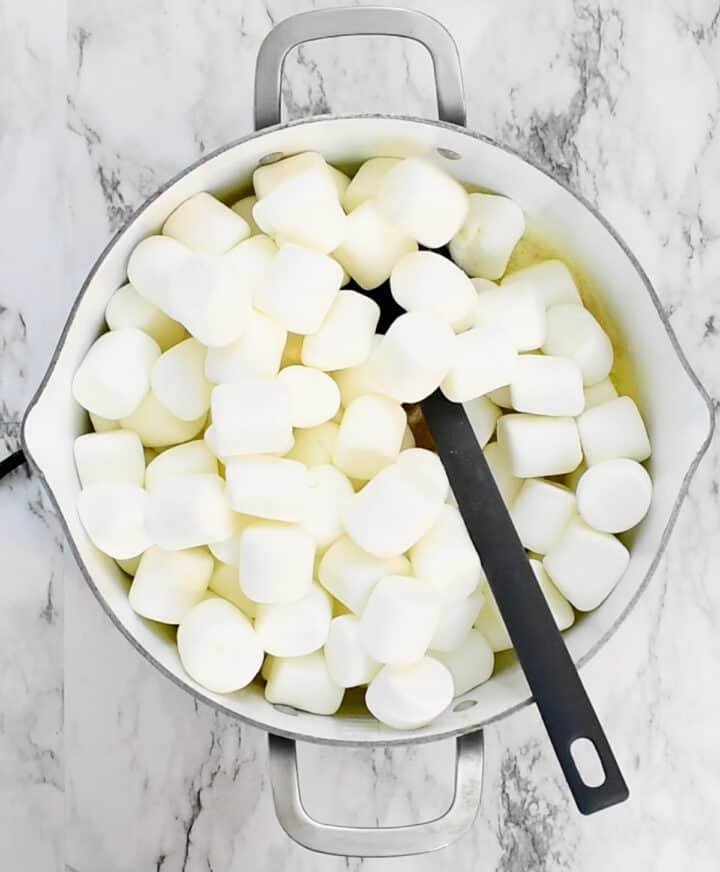 adding marshmallows to melted butter