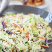 slaw with pulled chicken sandwich in background