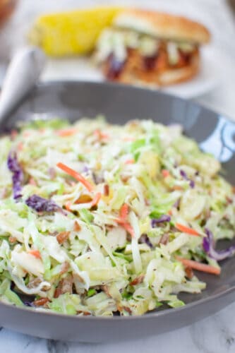 slaw with pulled chicken sandwich in background