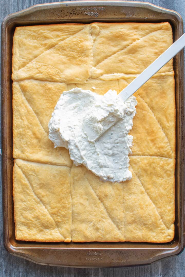 spreading ranch dressing mixture onto baked crescent roll dough