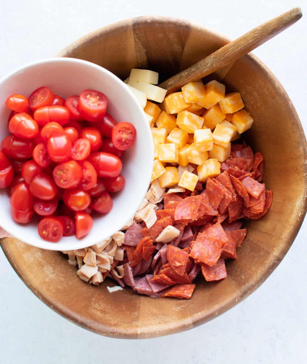 adding grape tomatoes to large bowl