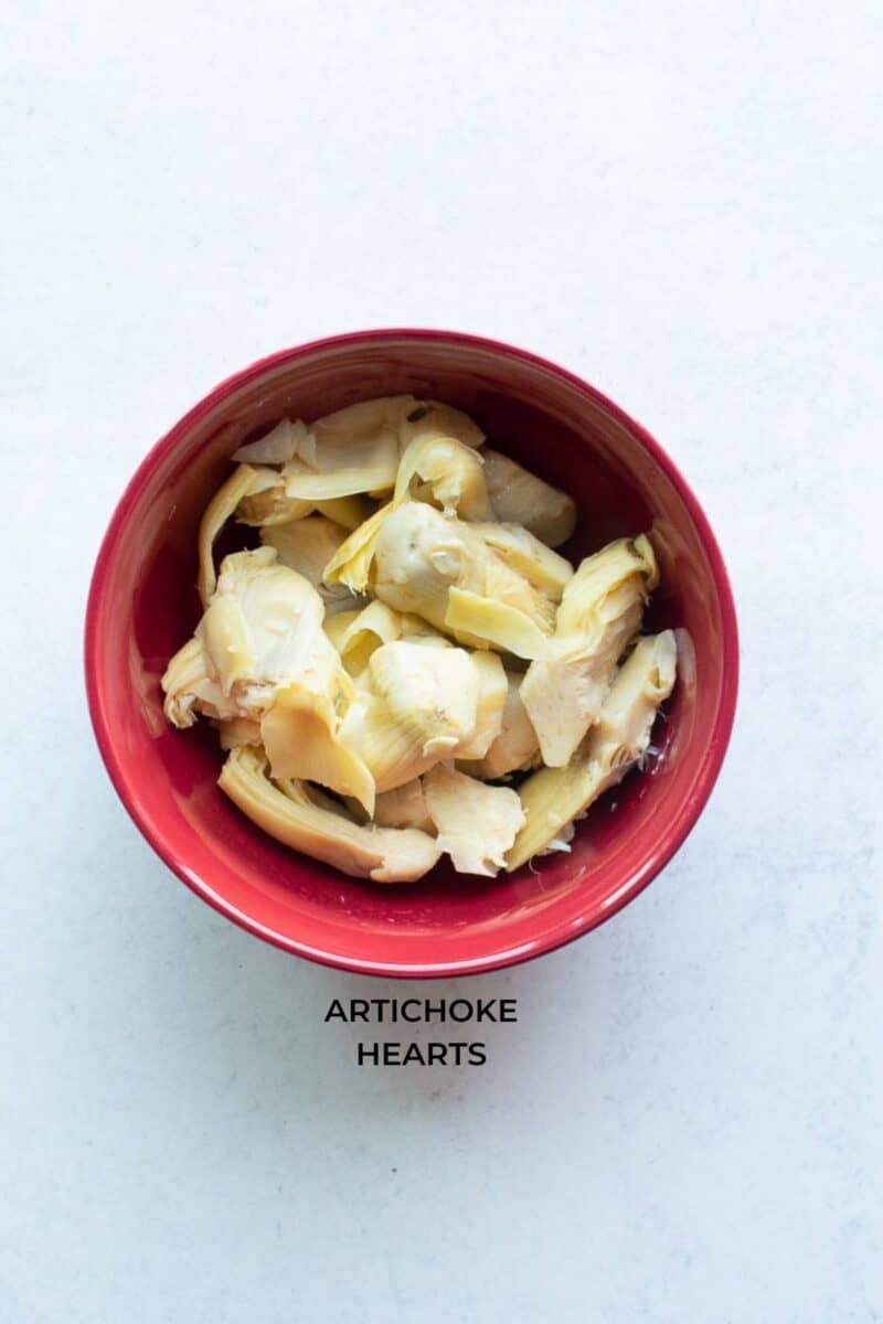 chopped artichoke hearts in a red bowl