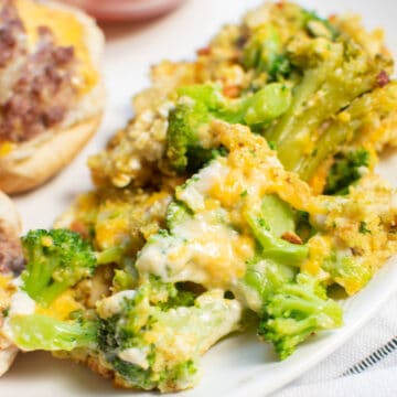 close up of a serving of cheesy broccoli casserole on a plate