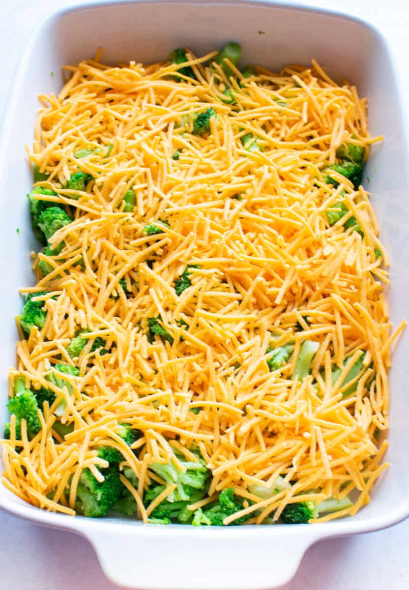 shredded cheddar cheese on top of broccoli