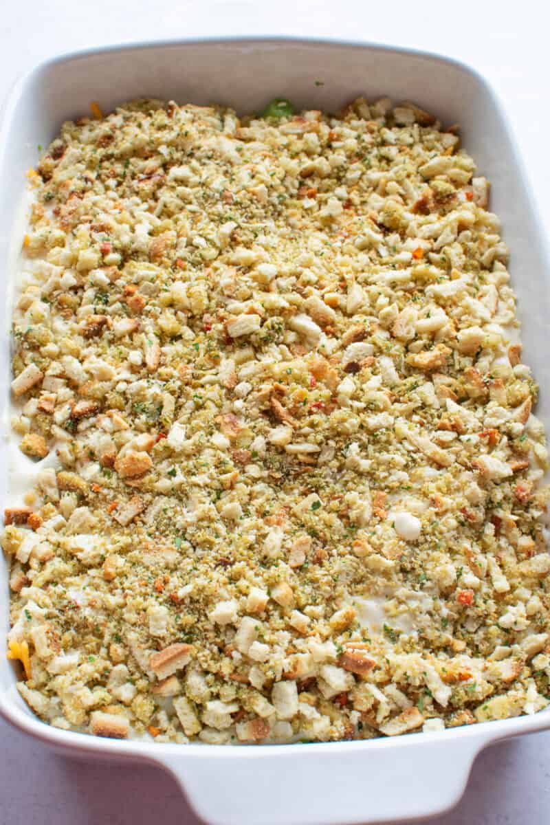 broccoli casserole is topped with stuffing mix and is ready to be baked