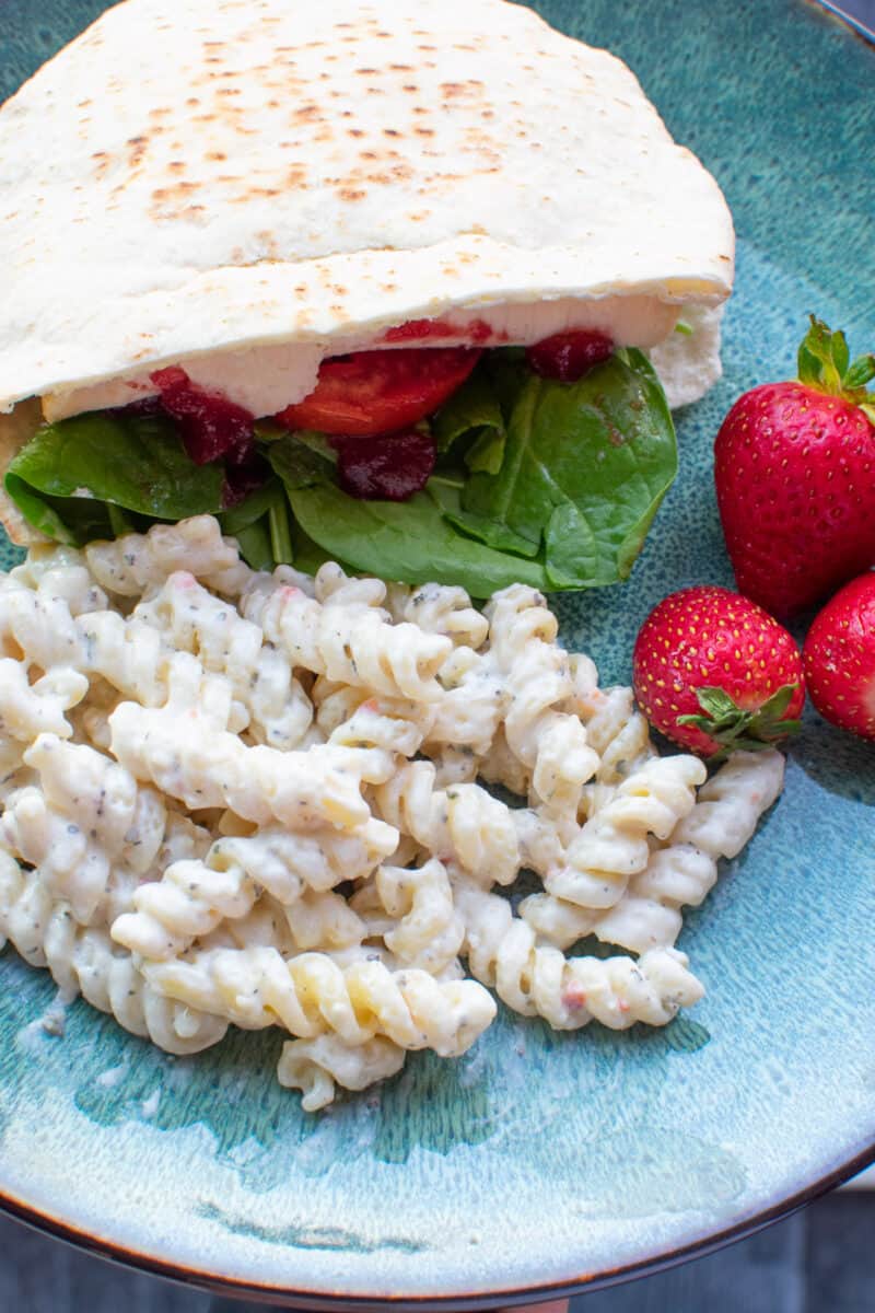 Creamy Italian Pasta Salad on a plate with a sandwich and strawberries