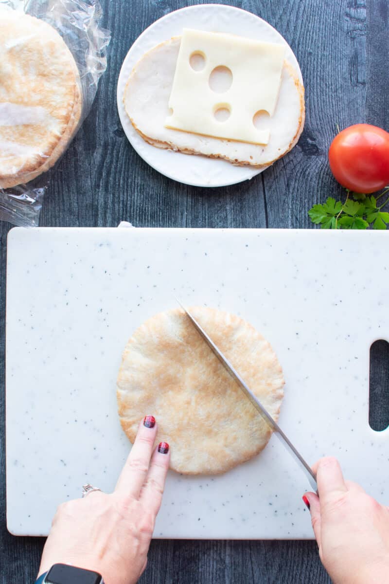 cutting top of pita bread on a cutting board