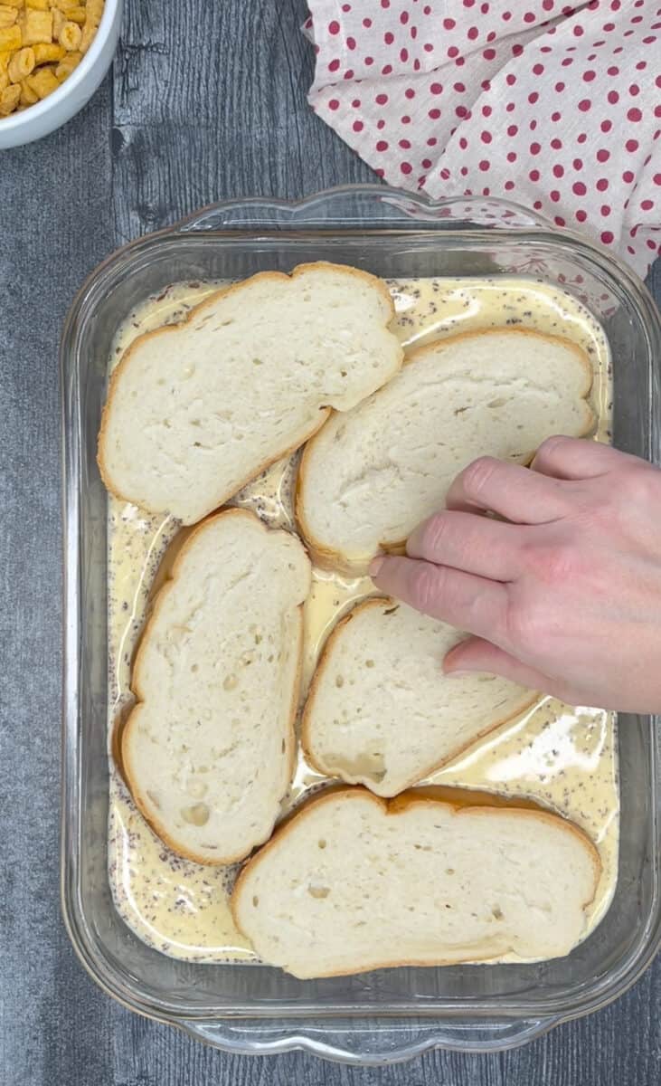 putting sliced bread in baking dish with egg mixture to soak