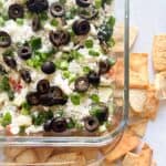 Closeup overhead shot of greek layer dip with pita chips