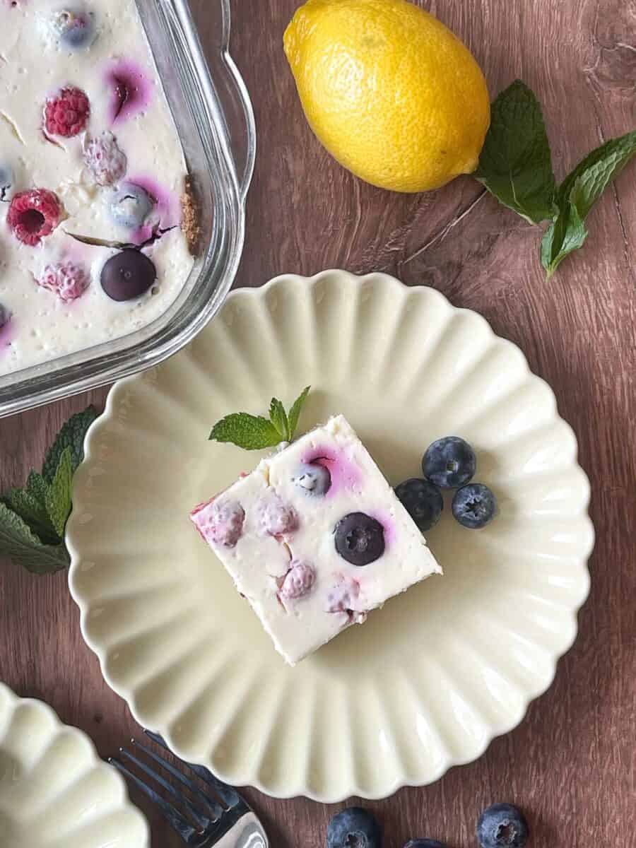 Overhead view of a slice of lemon berry cheesecake on a scalloped plate