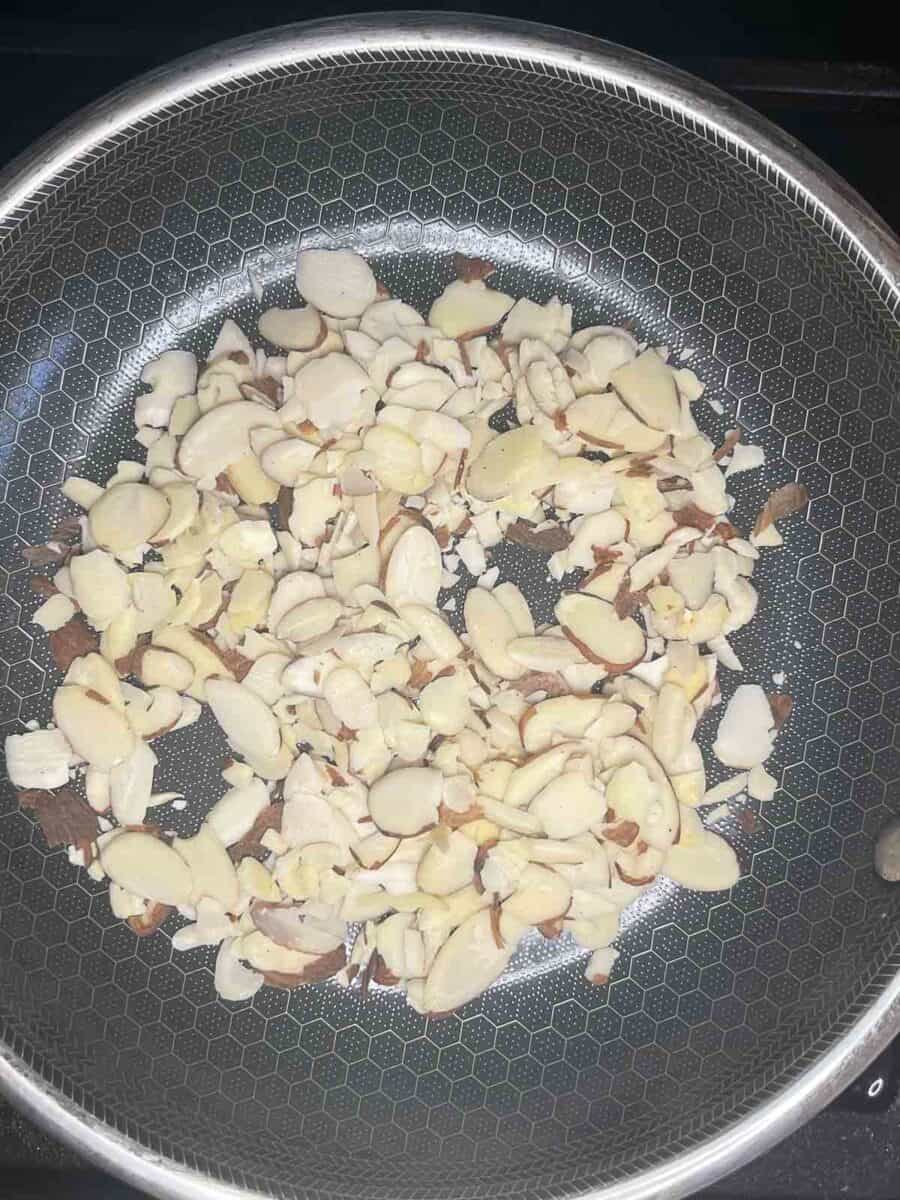 almonds added to a skillet ready to be toasted