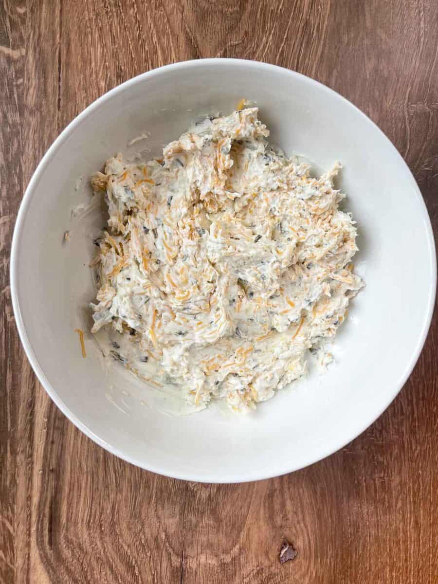 cheese mixture is well blended in a white mixing bowl