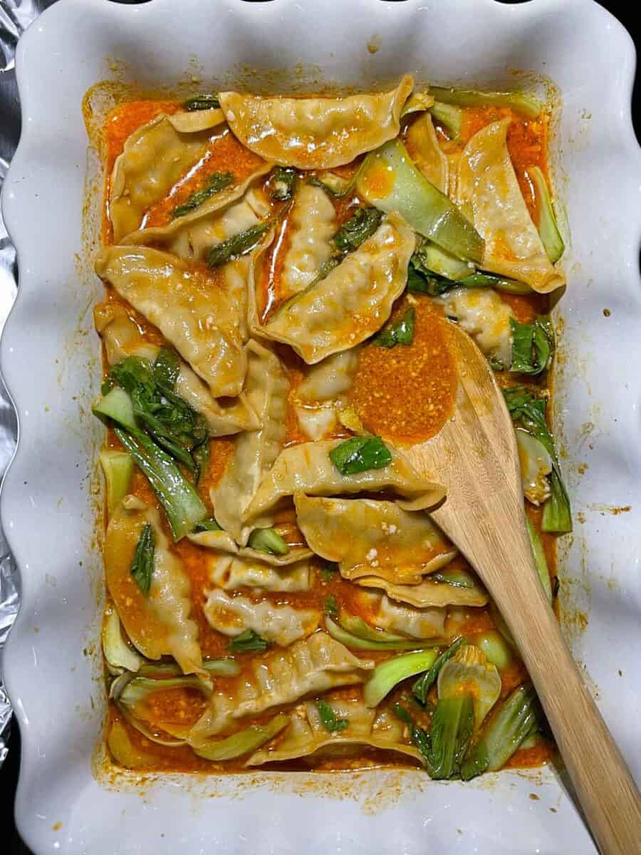 baked dumplings in white dish after stirring everything together