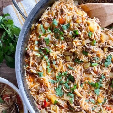 overhead view of finished fideo with ground beef in a skillet sprinkled with parsley