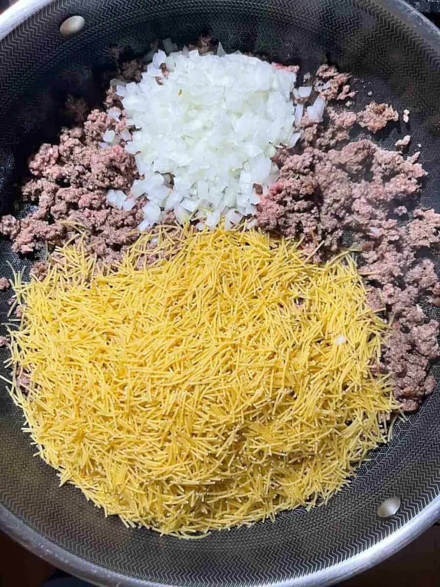 added fideo and onions to the browned ground beef