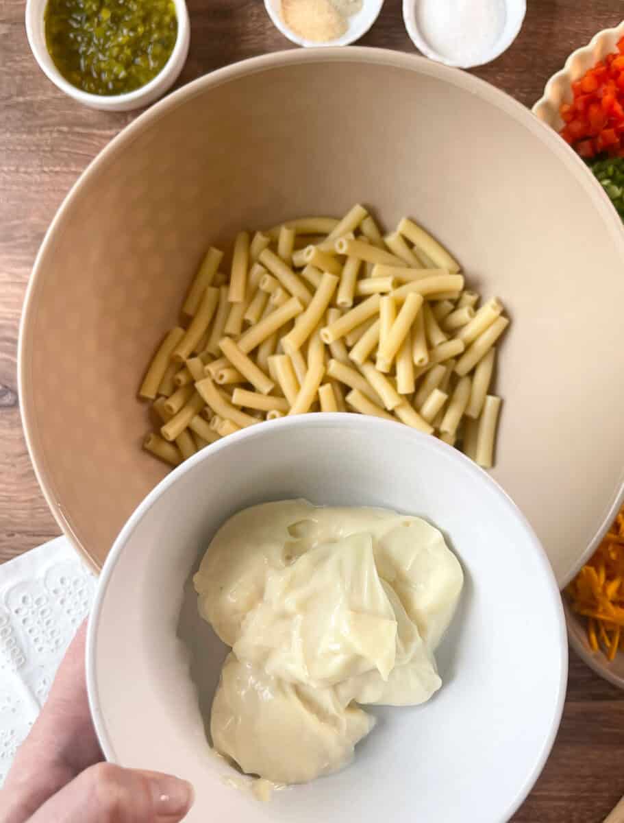 Adding mayo to cooked macaroni in bowl