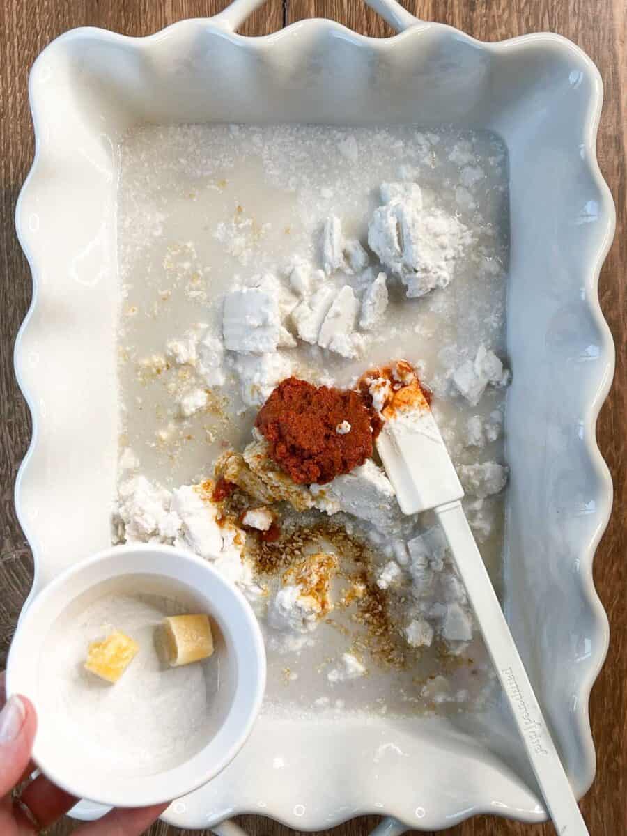 about to add garlic and ginger cubes to white dish