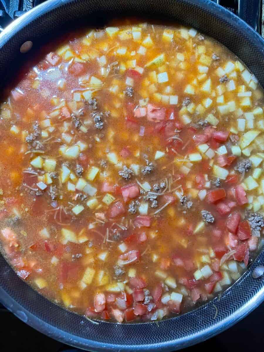 broth is added to the ground beef mixture in the skillet