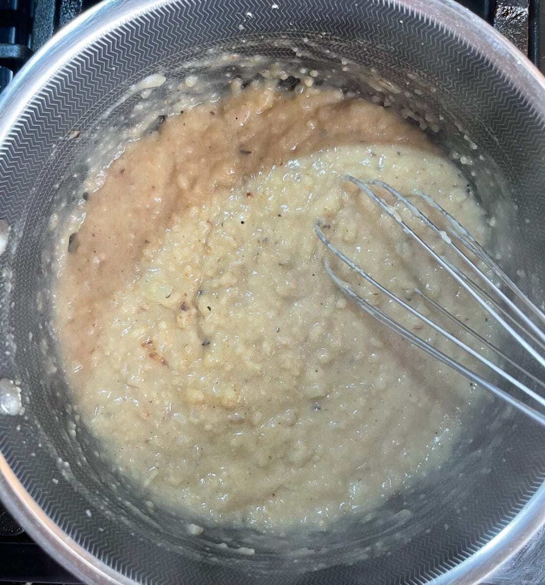 Whisking flour in pot with cooked onions