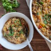 part of skillet showing of cooked fideo next to a small with bowl with a serving of the fideo in it
