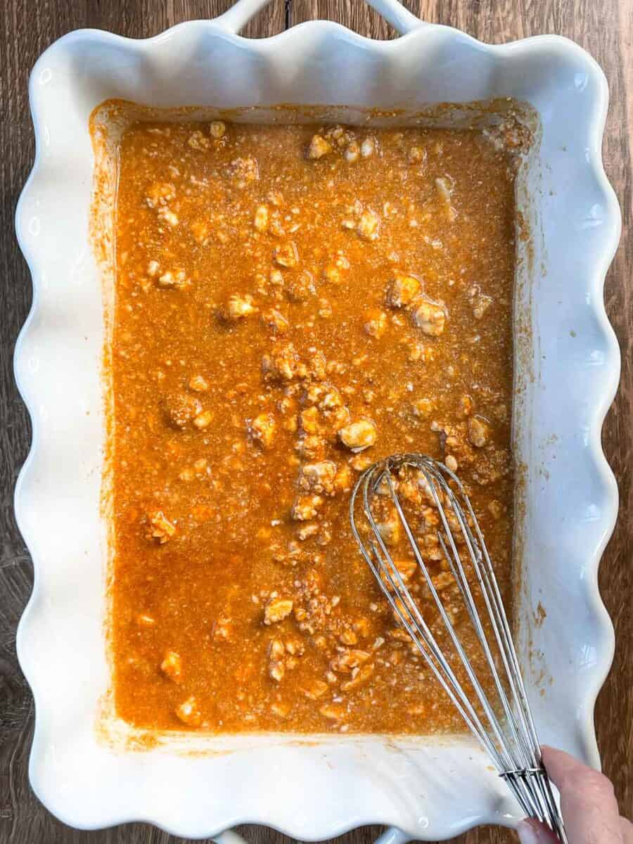 stirring all ingredients in white baking dish with a metal whisk