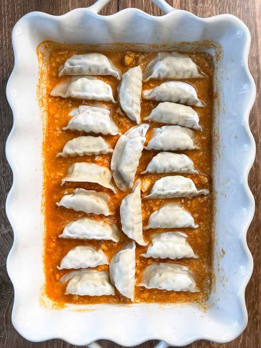 dumplings have been placed in the white dish in three neat rows